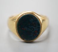 A yellow metal (stamped 18) and bloodstone set oval ring, size S/T, gross 7.9 grams.