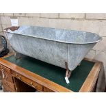 A vintage galvanised trough on wrought iron feet, length 146cm, depth 62cm, height 49cm