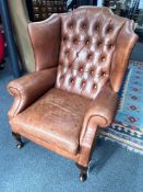 A Victorian style tan leather buttoned wingback armchair, width 83cm, depth 84cm, height 108cm