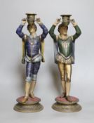 A pair of painted spelter figural candlesticks,35.5 cms high,