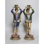 A pair of painted spelter figural candlesticks,35.5 cms high,