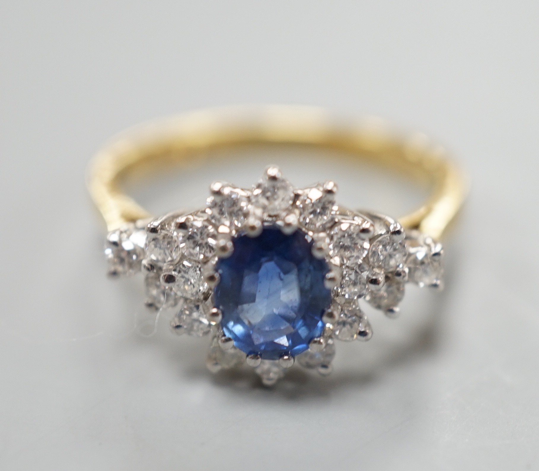 A modern 18ct gold, sapphire and diamond set elliptical shaped cluster dress ring, size N, gross