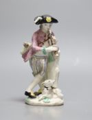 A Bow figure of a boy with dog playing the pipes,25.5 cms high,