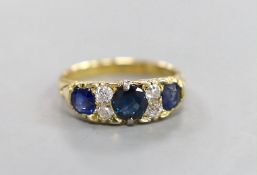 A late Victorian 18ct gold, three stone sapphire, and four stone diamond set half hoop ring, with