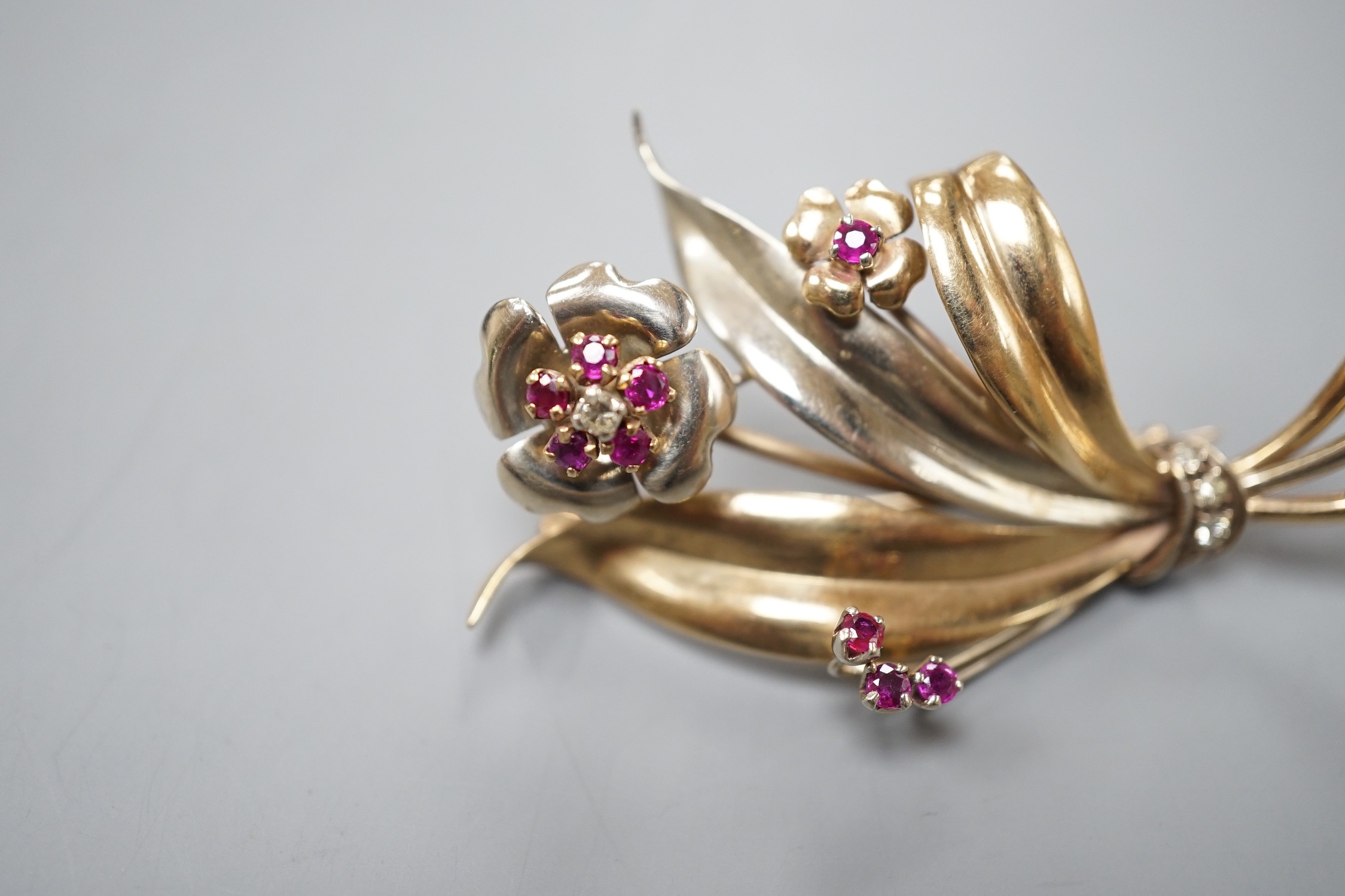 A two colour yellow metal, ruby and diamond cluster set floral spray brooch, 51mm, gross weight 8. - Image 2 of 4