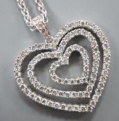 A modern 18k white metal and diamond set graduated concentric heart pendant, 27mm, on an 18ct