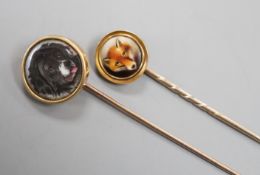 Two early 20th century yellow metal and enamel stick pins, both decorated with the head of a dog,