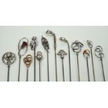 A collection of thirteen assorted early 20th century and later white or yellow metal hat pins,