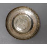 An engraved Middle Eastern? white metal dish with inset coin, 11.7cm, gross weight, 90 grams.