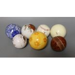 Three carpet bowls, three cricket balls and a polo ball,