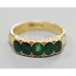 A modern 18ct gold and graduated five stone emerald set half hoop ring, with diamond chip spacers,