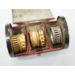 A rare Regency morocco leather mounted white metal cylindrical ring box containing five pinchbeck/
