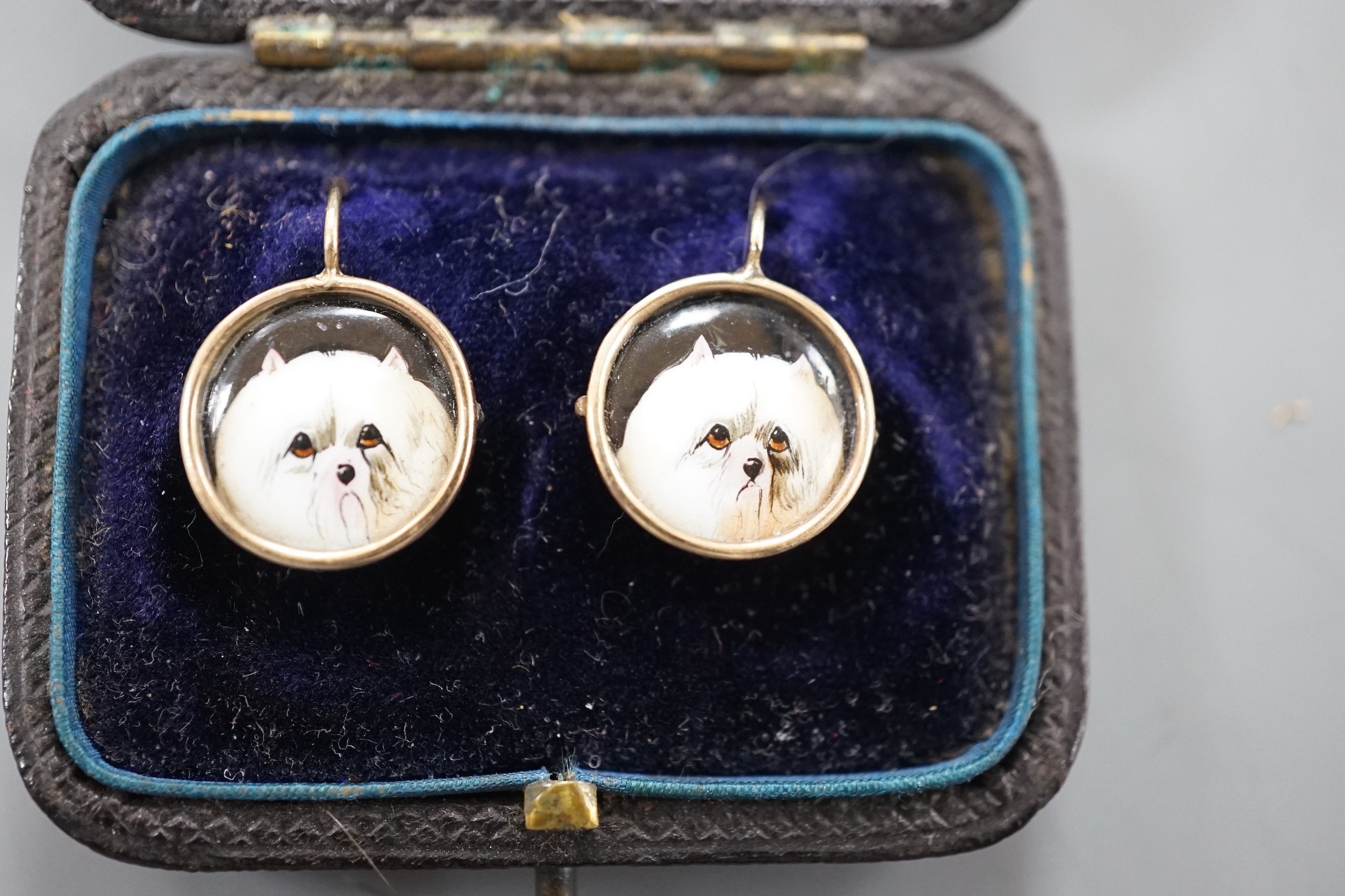 A cased pair of yellow metal and circular enamel earrings, decorated with the heads of a dog, - Image 4 of 4