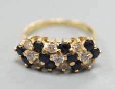 A modern 18ct, sapphire and diamond cluster set seven row half hoop ring, size P, gross weight 5.4