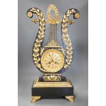 A 19th century French black lyre shaped clock, with gilt leaf decoration on scroll feet, 57cm tall