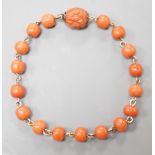 A yellow metal and coral bead bracelet, with carved coral bead clasp, 19.5cm.