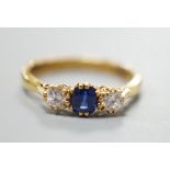 A modern 18ct gold, sapphire and diamond set three stone ring, size S, gross weight 4.4 grams, the