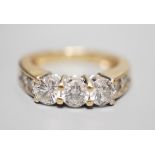 A 14k yellow metal and three stone diamond ring, with four stone diamond set shoulders, size K,