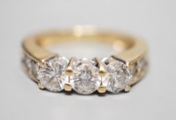 A 14k yellow metal and three stone diamond ring, with four stone diamond set shoulders, size K,