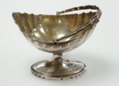 A George III Irish engraved silver bats wing oval shaped pedestal sugar basket, by Richard Sawyer,