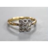 A 1920's 18ct and nine stone diamond cluster set tablet ring, size R, gross weight 4 grams.