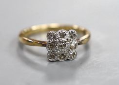 A 1920's 18ct and nine stone diamond cluster set tablet ring, size R, gross weight 4 grams.