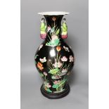 A Chinese famille noire vase, on plinth, 46 cms high,