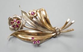 A two colour yellow metal, ruby and diamond cluster set floral spray brooch, 51mm, gross weight 8.