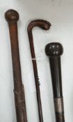 A bull's pizzle walking stick and two other carved wood sticks, largest 93cm