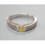 A modern sandblasted platinum and solitaire rectangular cut fancy yellow diamond set ring, size M/N,