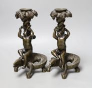 A pair of late 19th century bronze candlesticks modelled as cherubs riding crocodiles, 21.5cm