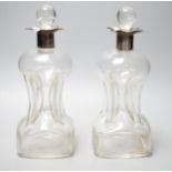 A pair of Edwardian silver mounted hourglass shaped glass decanters with stoppers, by William Hutton