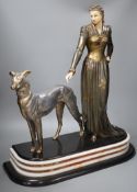An Art Deco spelter and composition figure of a lady and a hound, signed Menneville,57 cms high,