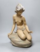 A large Lladro stoneware figure of a young girl seated on a rock, 42cm