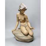 A large Lladro stoneware figure of a young girl seated on a rock, 42cm