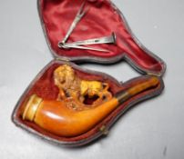A cased Meerschaum cheroot holder with a carved wooden lion decoration with silver cleaner in fitted