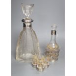 An early 20th century French white metal mounted gilded glass decanter and stopper and four matching