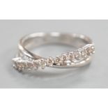 A modern 18ct white gold and diamond chip set half hoop crossover ring, size O, gross weight 3.9