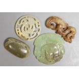 Four Chinese jade carvings, to include a face plaque, a dragon plaque, disc and a pebble carving,