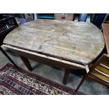 A 19th century French oak and pine circular drop leaf kitchen table, length 130cm, depth 90cm,