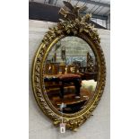 A 19th century French giltwood and composition oval wall mirror with pierced scrolling pediment,