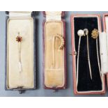 Three assorted early to mid 20th century yellow metal and gem set stick pins including diamond