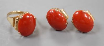 A 14k yellow metal and cabochon coral set oval ring, size N and a pair of matching earrings, lacking