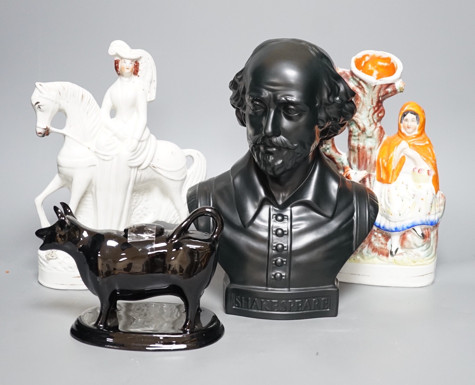 A Wedgwood glazed black basalt bust of Shakespeare, two Victorian Staffordshire figures and a cow