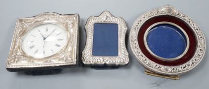 A modern silver mounted desk timepiece, 15.2cm and two mounted photograph frames, including