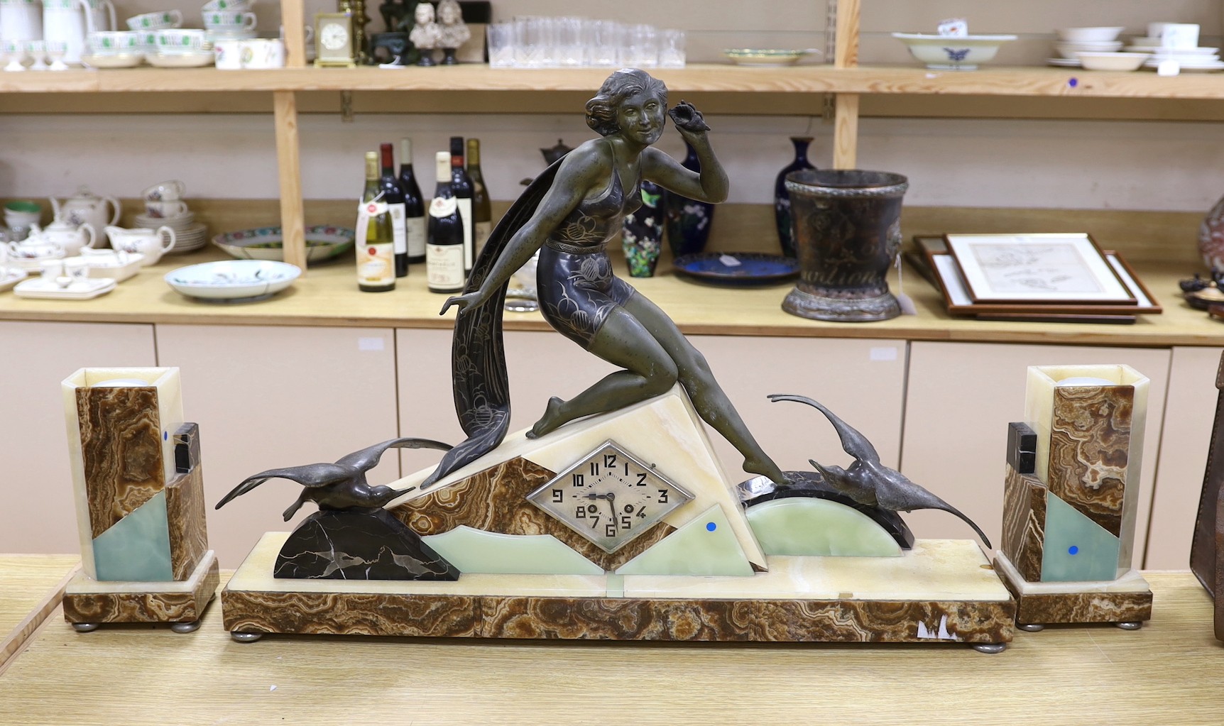 A large Art Deco spelter and marble clock garniture with a figural seaside mount, 59cm tall