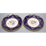 A pair of Coalport floral plates with cobalt blue borders having raised and flat gilding, both by