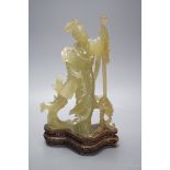 A Chinese carved bowenite jade figure of a lady on a hardwood stand 27cm