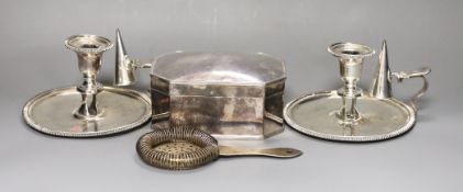 A pair of silver plated chambersticks, a plated octagonal box and cover and a plated strainer.