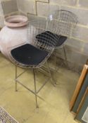 A pair of Harry Bertoia style chrome wired bar chairs with black leather seat pads, width 75cm,